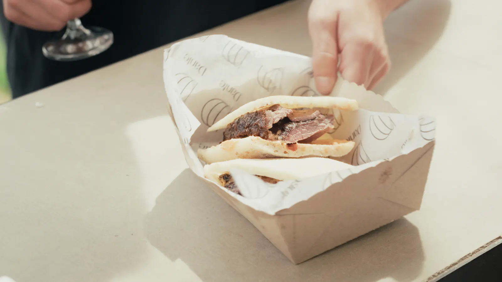 Braised beef sandwich in its box, on the table to help yourself