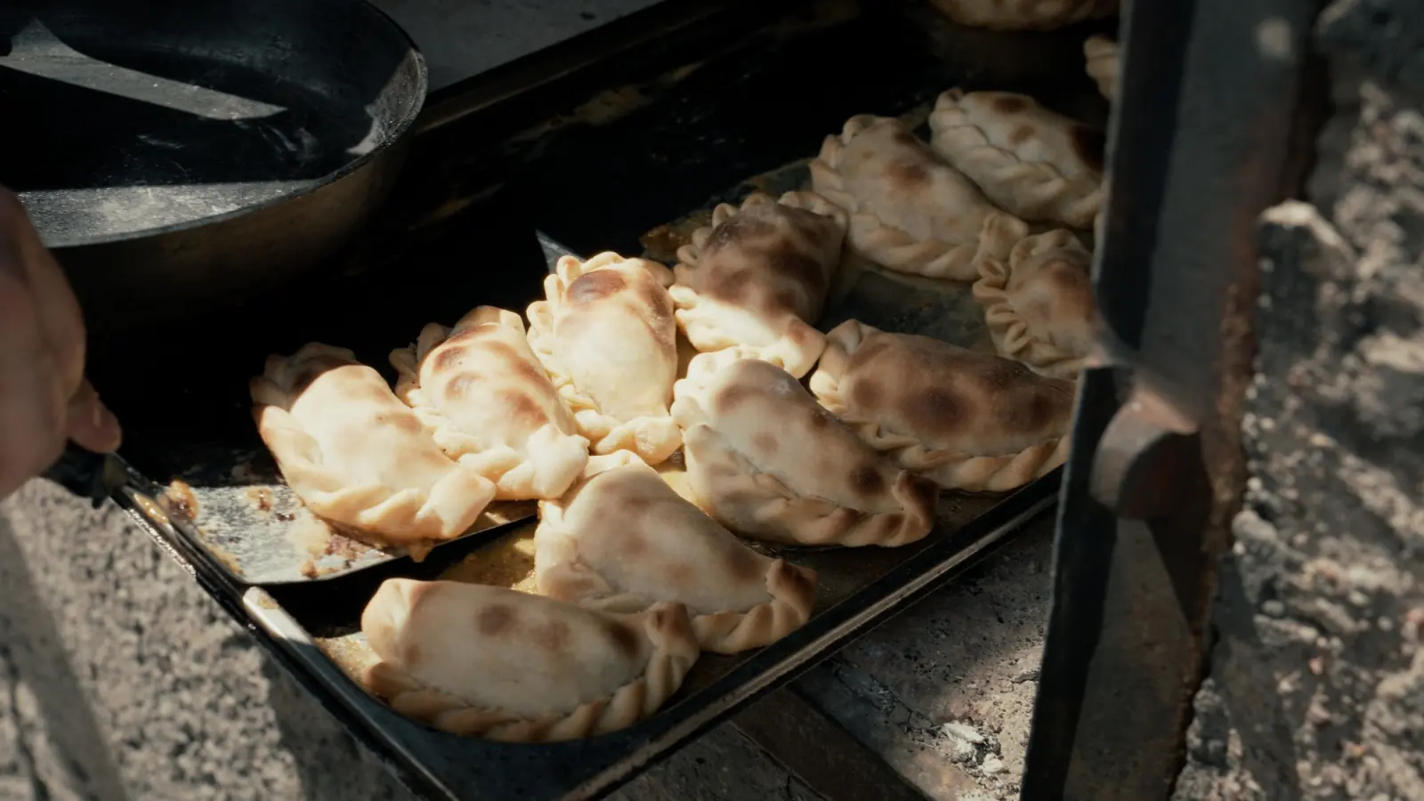 Tray of golden beef empanadas coming out of the oven