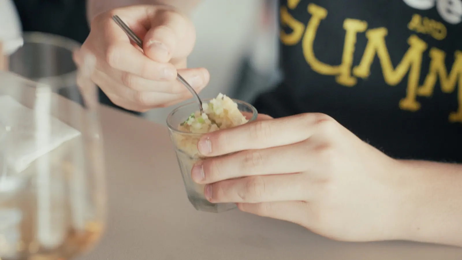 A guest eats apple and lemon verbena granita from a small glass