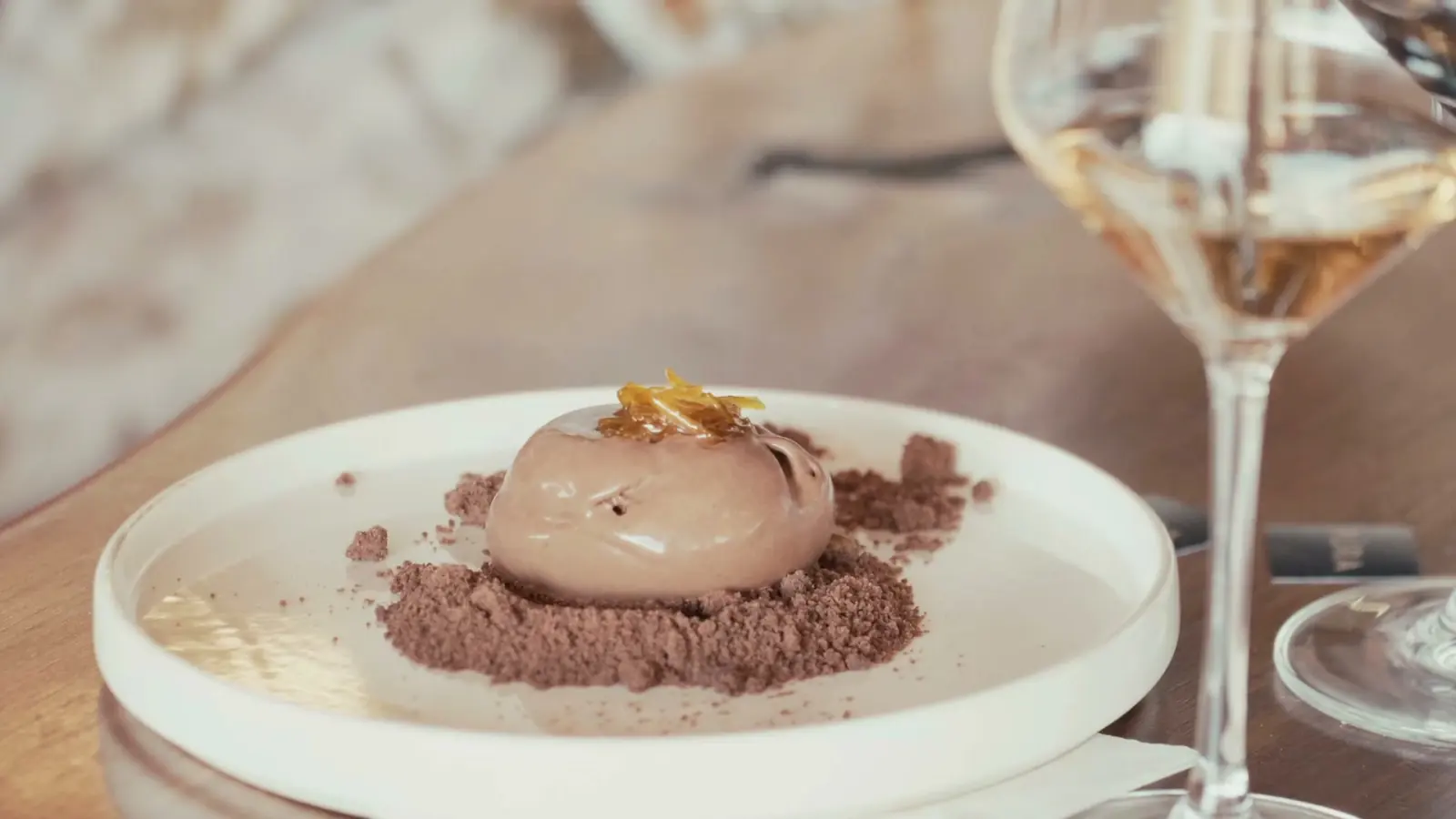 Chocolate dessert served at the table next to a glass of wine